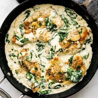 A skillet of chicken and spinach in creamy sauce