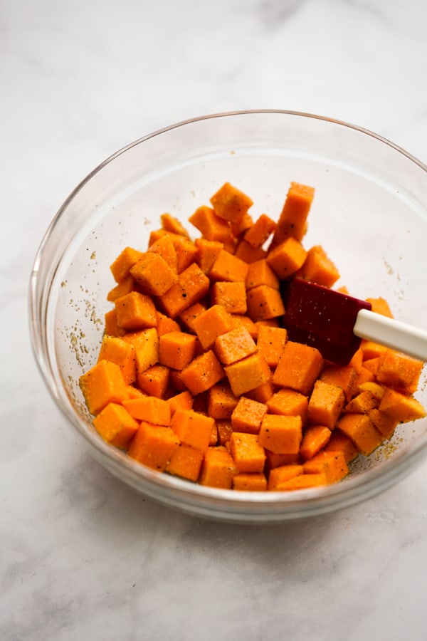 Seasoned, uncooked cubed butternut squash in a bowl