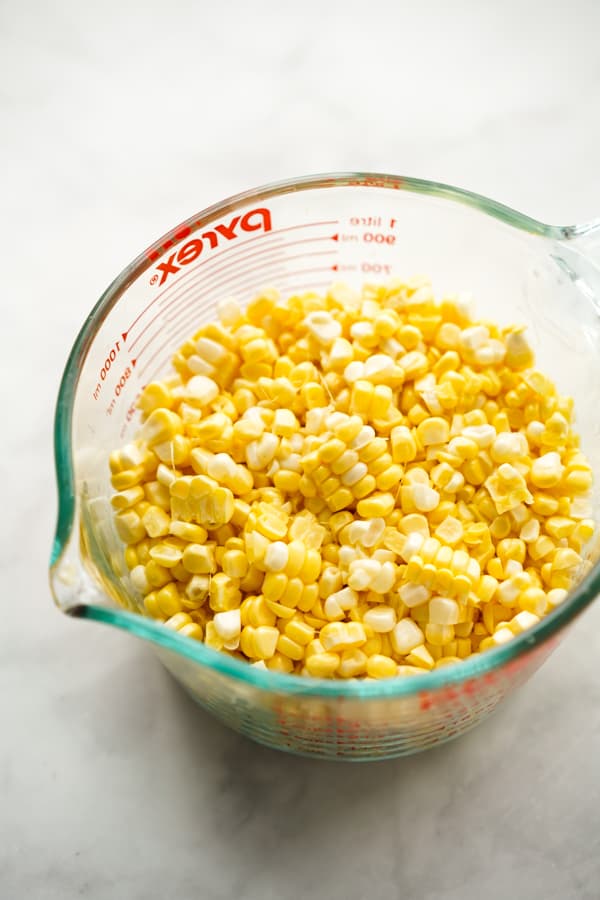 Fresh corn kernels in a measuring cup