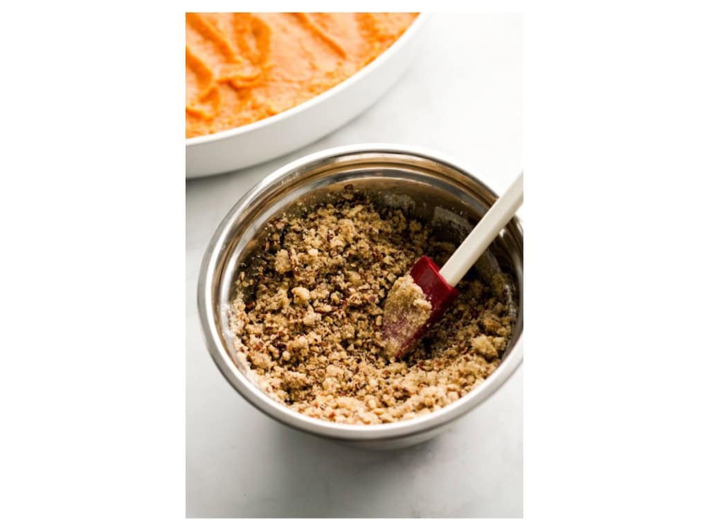 Crumbled pecan topping in a mixing bowl