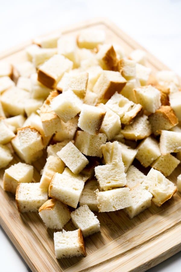 Brioche bread cut into cubes on a cutting board