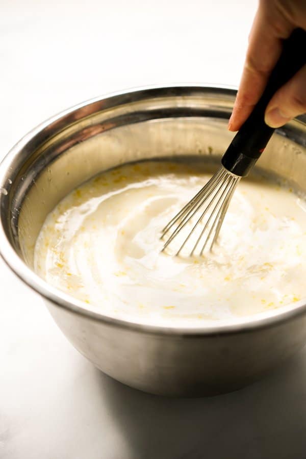 Mixing milk and egg mixture in a large mixing bowl