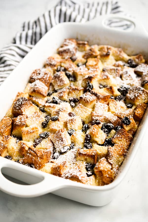 Brioche Bread Pudding in a rectangular casserole topped with powdered sugar