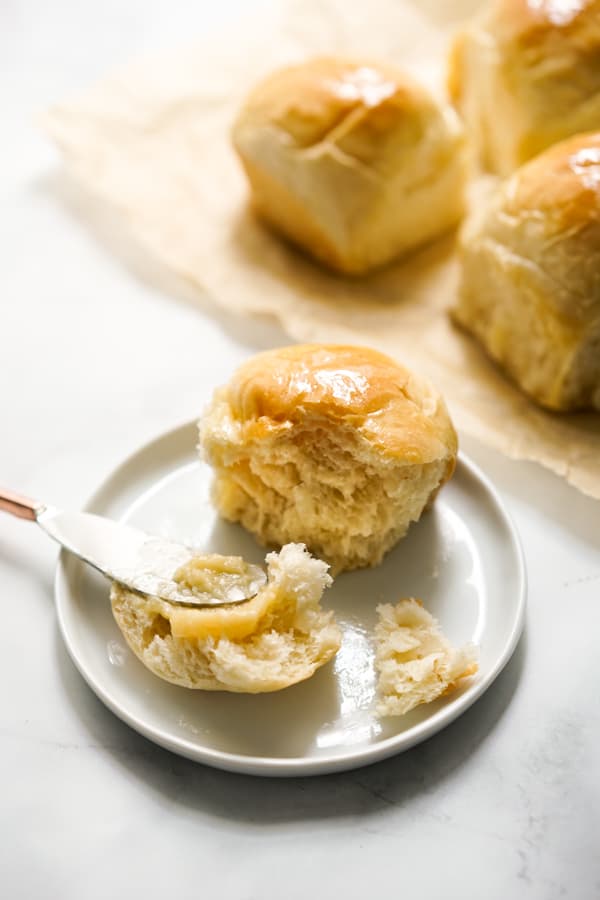 Spreading honey butter on to soft dinner rolls