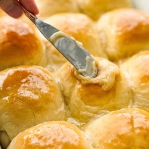 Spread honey butter onto yeast dinner rolls