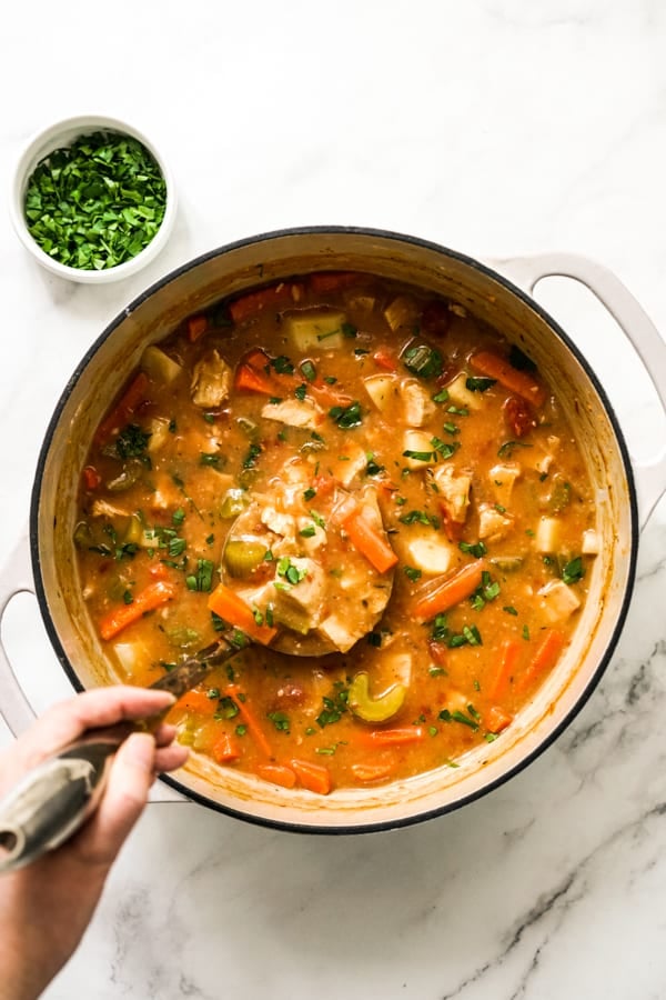 A large pot of chunky turkey stew combined with potatoes, carrots and tomatoes