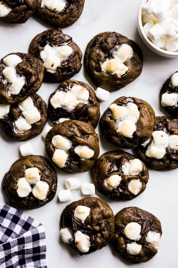 Lots of chocolate cookies with marshmallows on top and around it spread all over