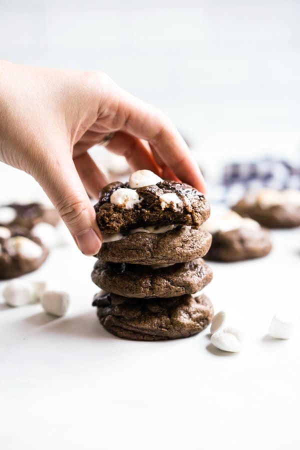 Picking up a piece of chocolate marshmallow cookie from a stack