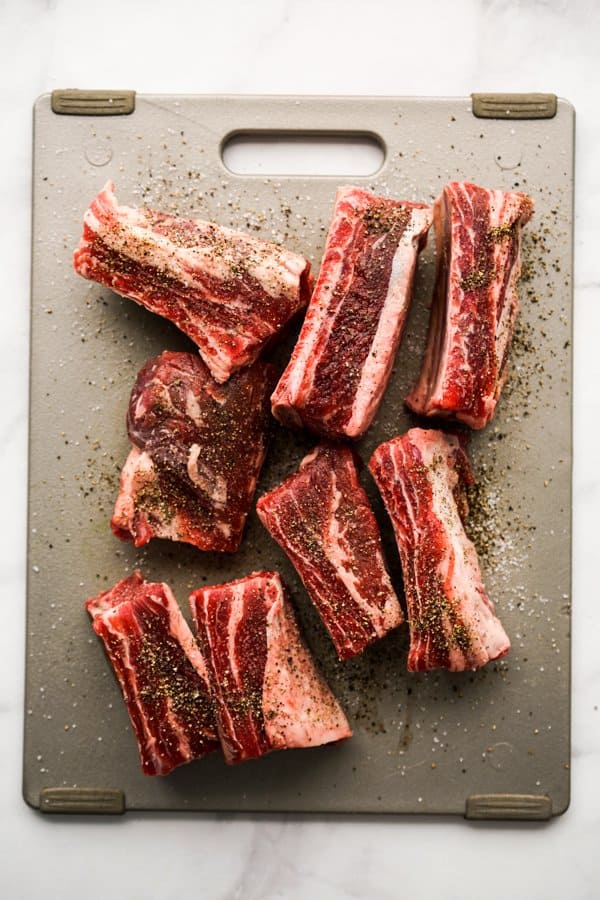 Uncooked short ribs seasoned with lots of salt and pepper