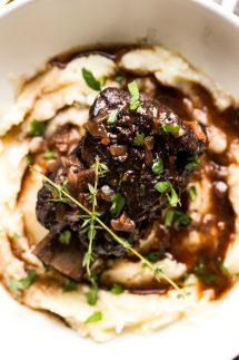 A bowl of mashed potatoes topped with red wine braised short ribs