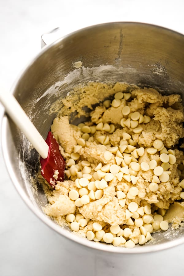 White chocolate chips with cookies dough in a large mixing bowl