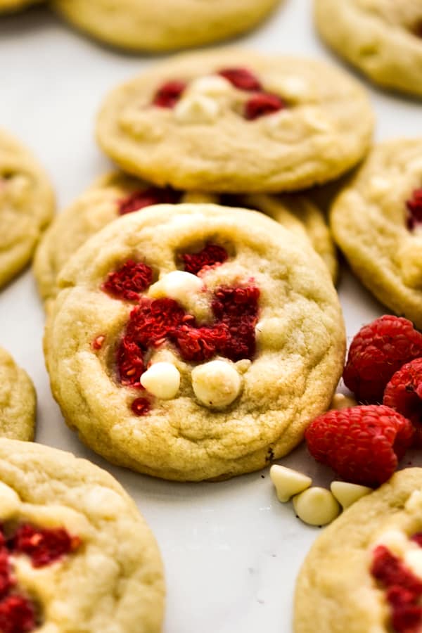 Closeup of a white cookies filled with white chocolate chips and raspberries