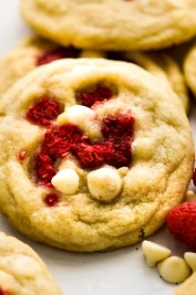 A round cookie filled with white chocolate chips and raspberries