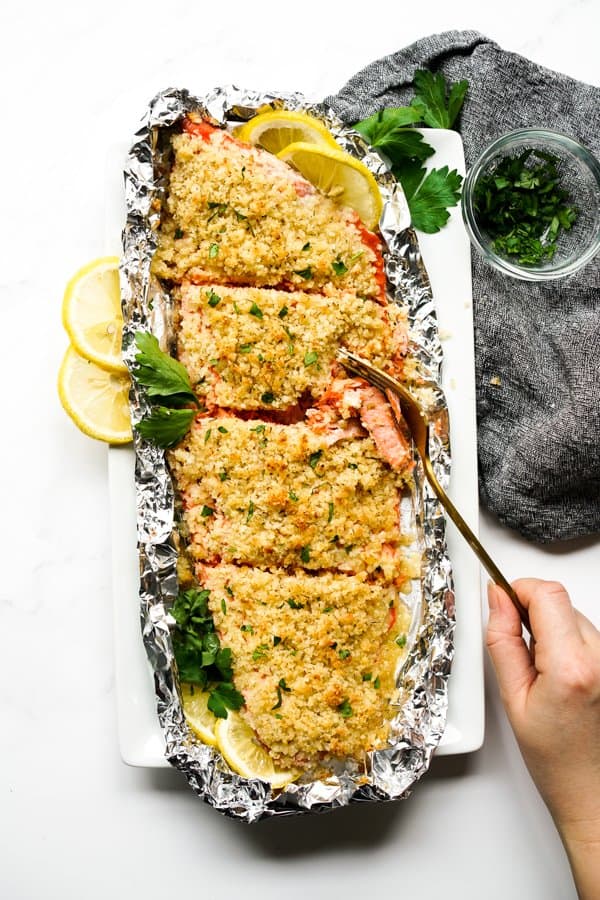 Using a fork to cut into a piece of salmon