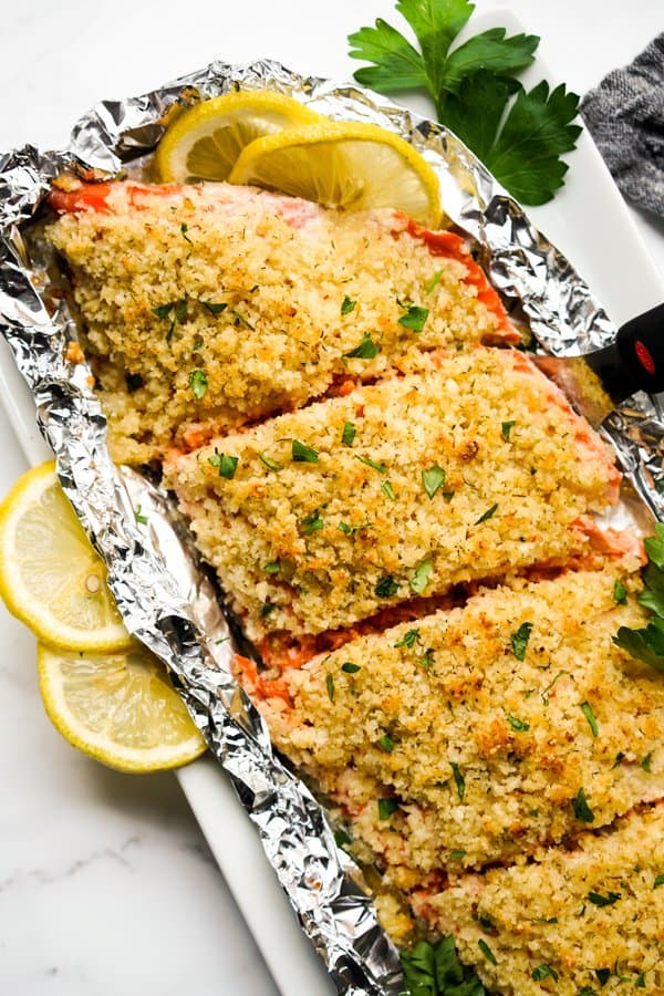 Large piece of salmon topped with a panko and parmesan crust, sliced into pieces