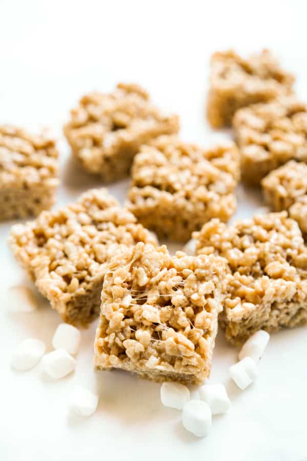 rice krispie treats in square pieces on a white surface with marshmallows