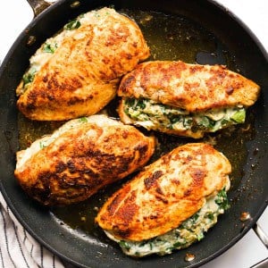 Baked Creamy Spinach Artichoke Stuffed Chicken on a round non stick skillet