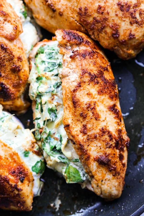 Closeup on seasoned chicken breast stuffed with creamy spinach artichoke filling