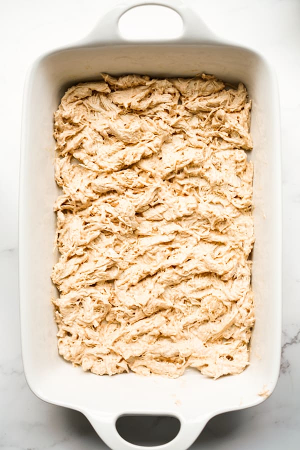 Creamy shredded chicken breast layered onto a casserole dish