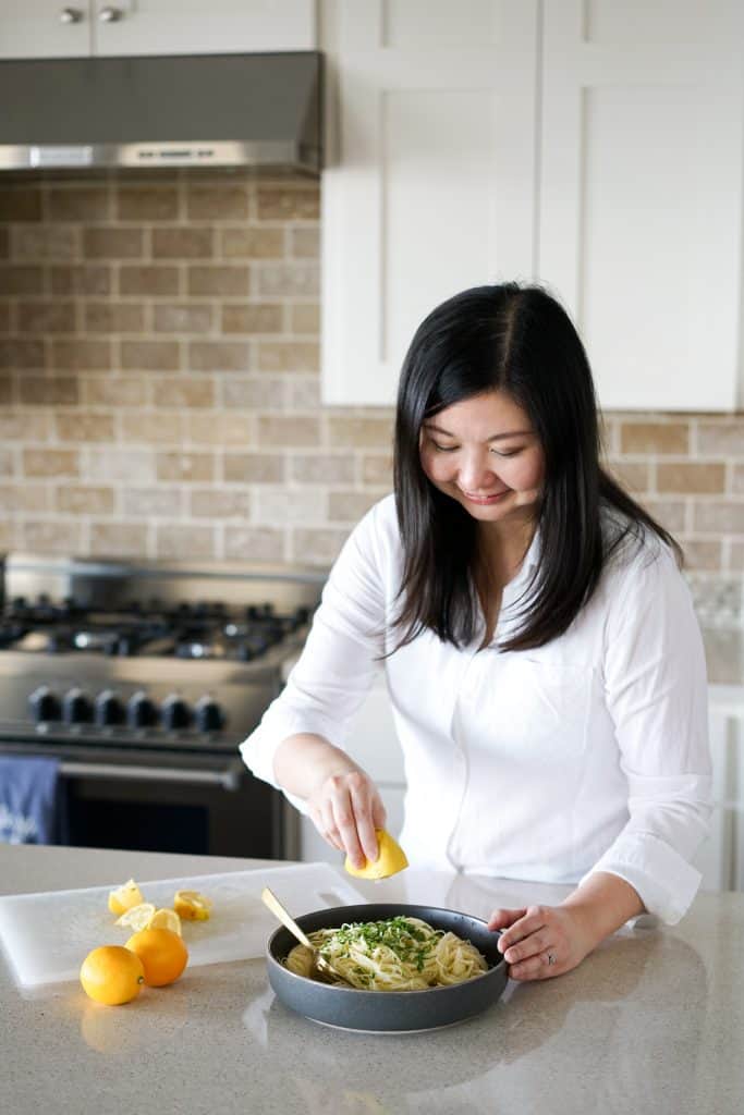 Sprinkling lemon juice onto pasta