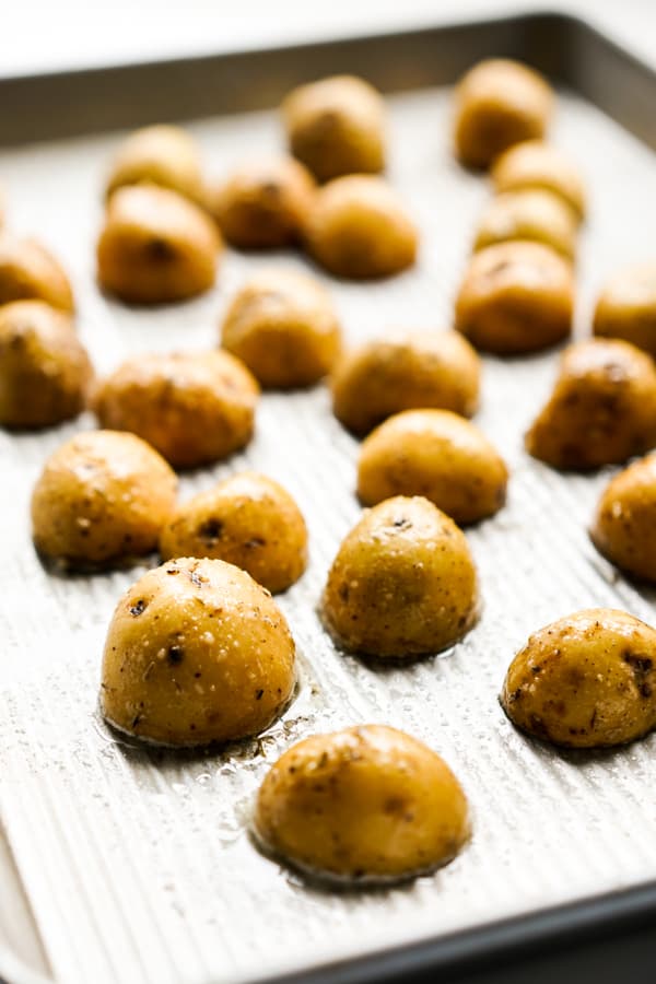 Placing halved small potatoes face down on grease baking sheet