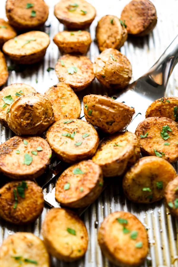 Scooping out roasted baby potatoes using a spatula