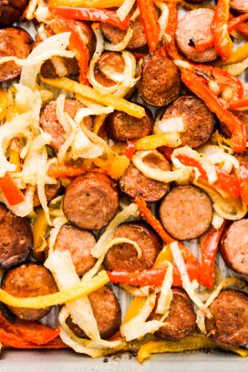 Sausage, red and orange peppers and onions on a pan