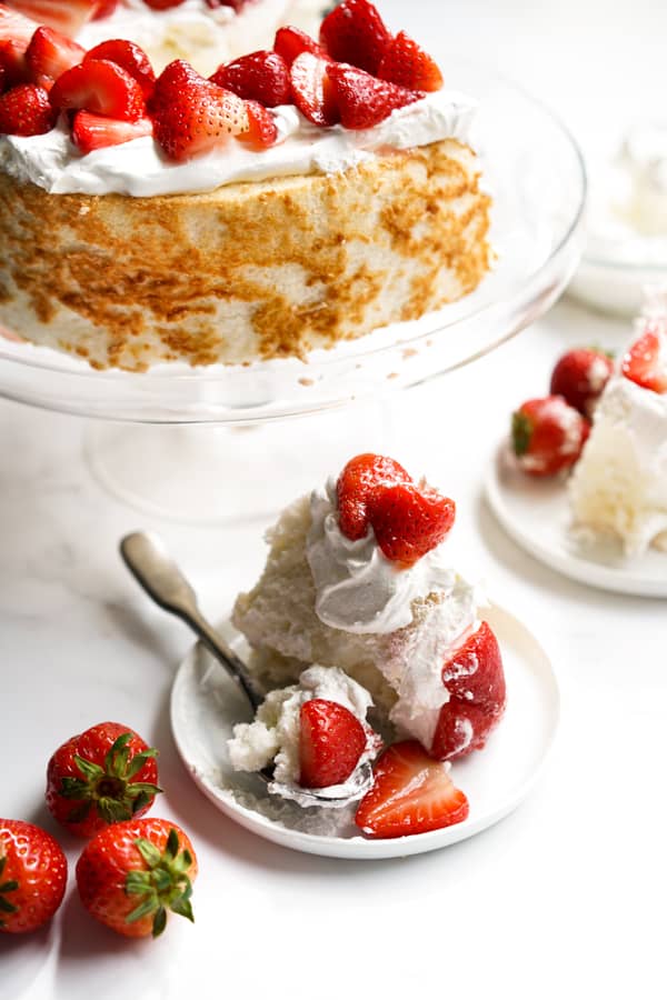 Angel food Strawberry Shortcake on a cake stand, and a few slices on plates