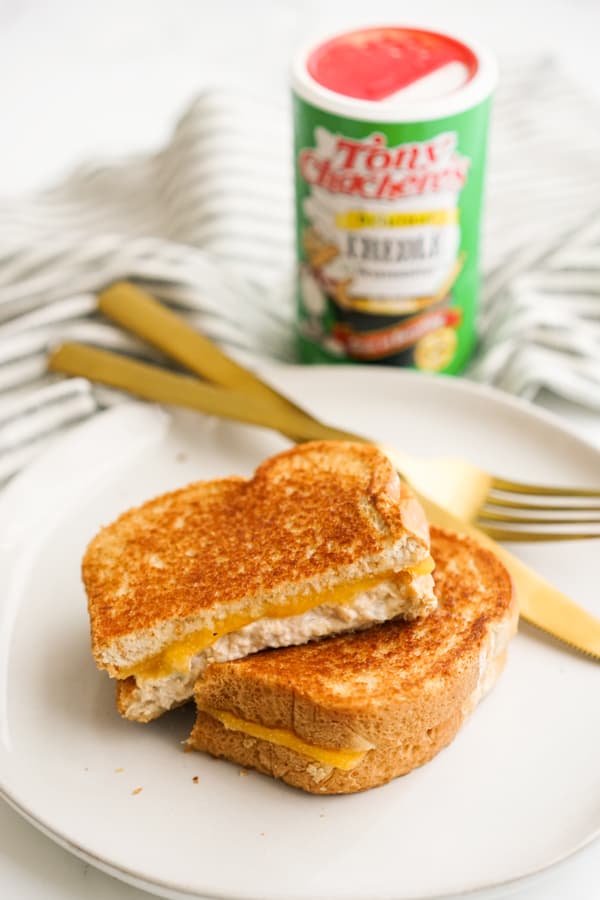 Two slices of Zesty Tuna Melt on a plate, with seasoning in the background