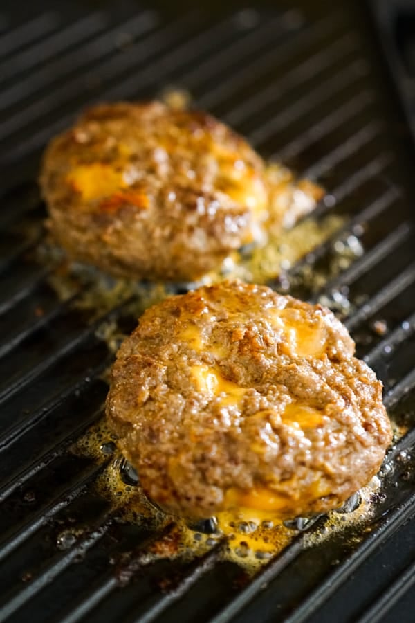 COoking Cheese Stuffed Burgers on the grill pan