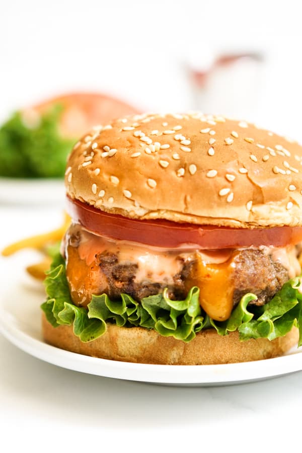 Closeup of cheese stuffed burger with lettuce and tomatoes