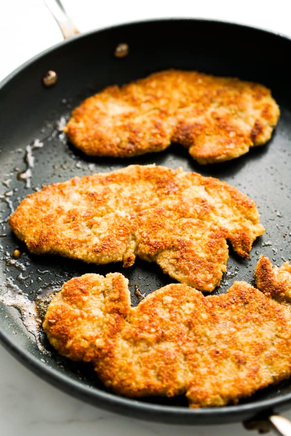 Three Pork Milanese cutlets on frying pan