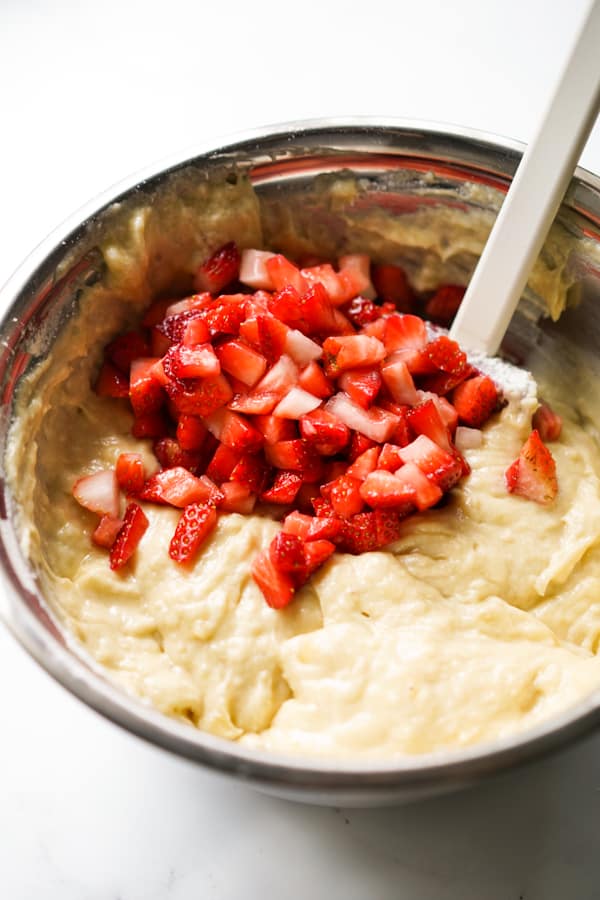 Chopped strawberries in Strawberry Banana Bread batter in a mixing bowl