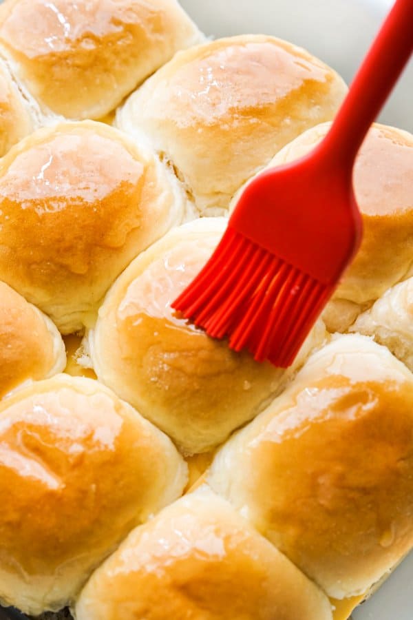Brushing top of Hawaiian rolls with butter