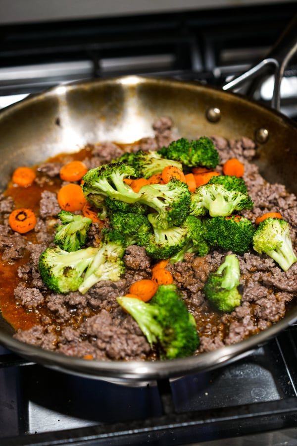 Ground beef, broccoli, carrots and Korean stir fry sauce in a skillet