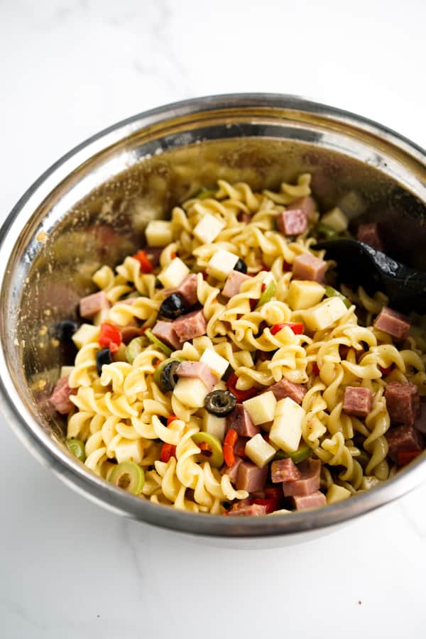Tossed Muffuletta Pasta Salad in a mixing bowl