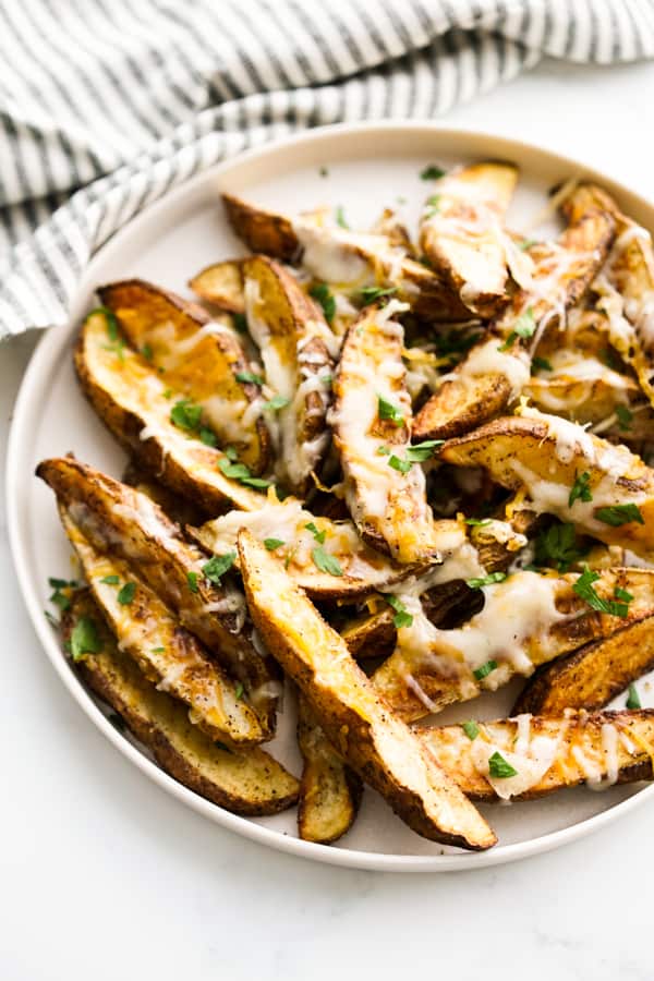 Baked Cheesy Potato Wedges on a round plate