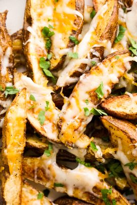 Closeup of Cheesy Potato wedges topped with chopped parsley