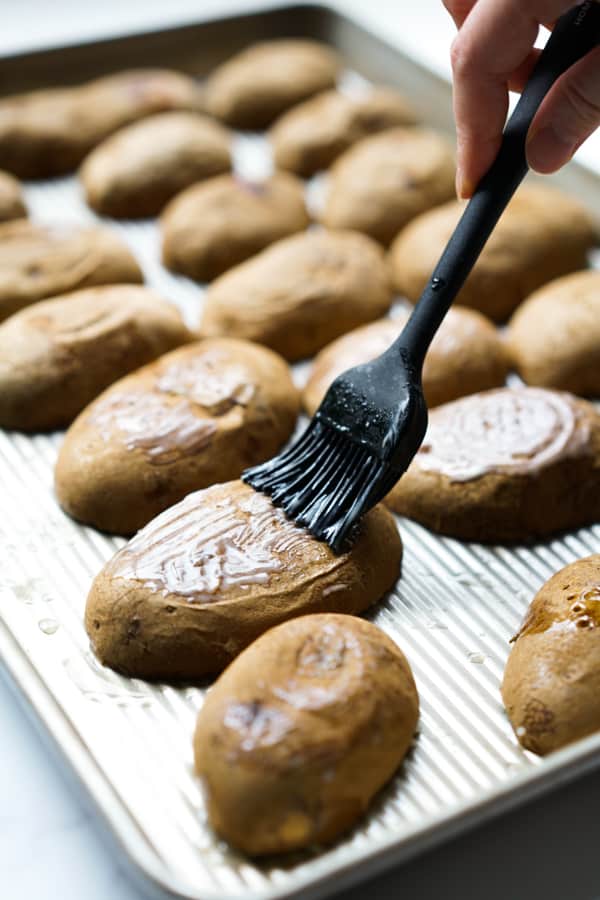 Brushing butter onto the back of potato skins