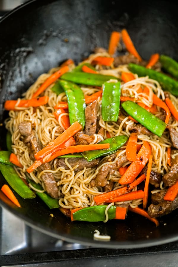 Noodles, beef, carrots and snap peas in the wok