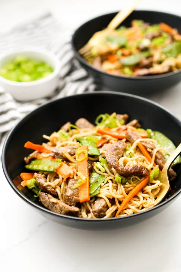 Two bowls of Mongolian Beef Noodles topped with vegetables