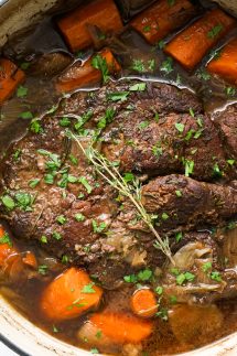 Top down view of Stovetop Pot ROast in a large pot with carrots and juices
