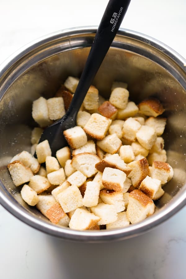 A bowl of bread cubed with spatula in the bowl