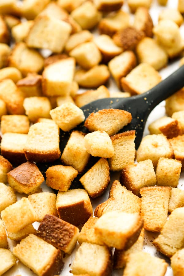A spatula scooping up croutons