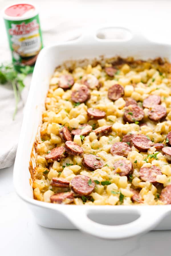 Side view of a rectangular potato casserole loaded with cheese and sausage
