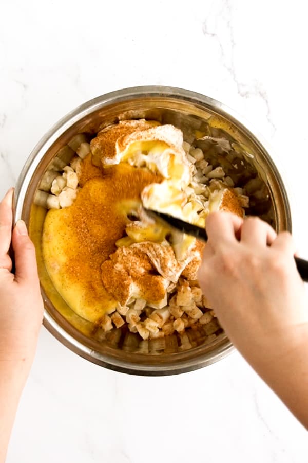 Mixing potatoes with sour cream, chicken soup and seasoning