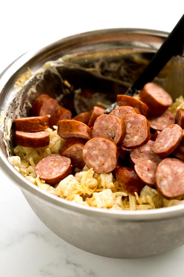 Sausage with potato mixture in mixing bowl