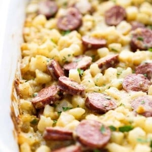closeup of diced potatoes, sausage and cheese in a casserole