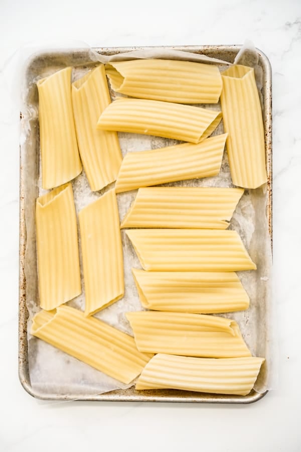 manicotti pasta on a baking sheet lined with wax paper