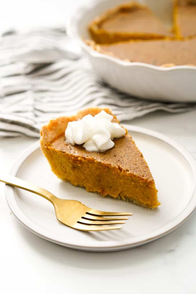 A slice of pumpkin pie with whipped cream on top